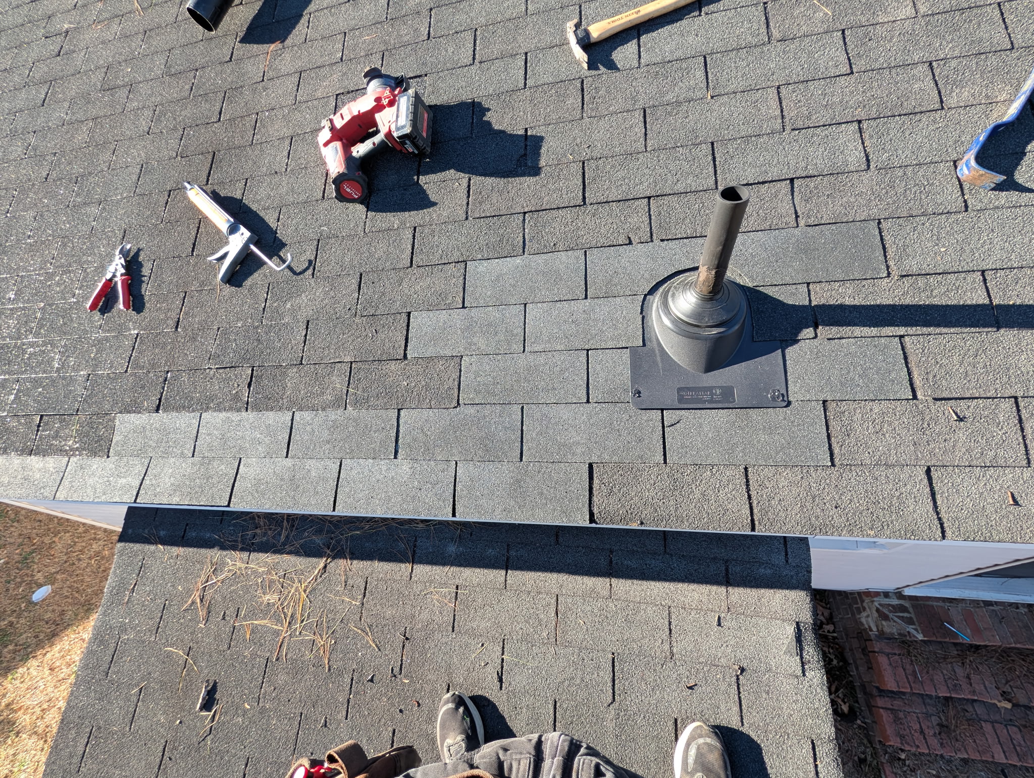 Licensed roofer repairing damaged shingles on a residential roof in Zebulon, NC