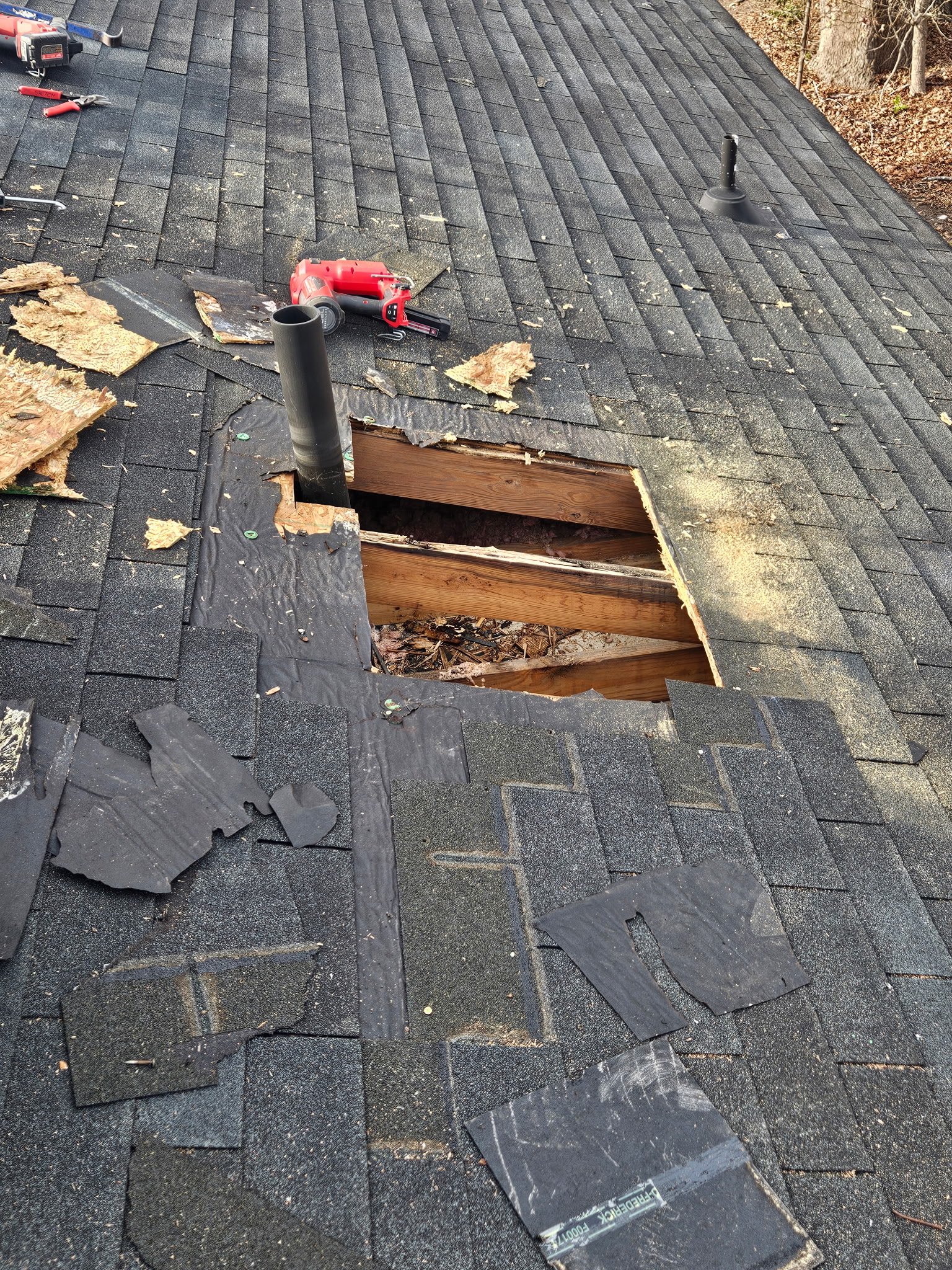Licensed roofer securing replacement shingles during storm damage repair on Wendell NC residence